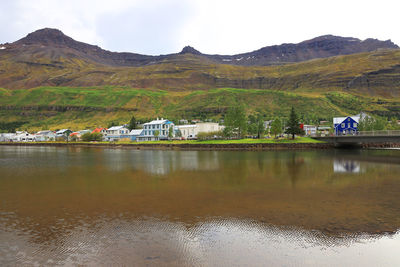 Reflection of houses in lake against mountains