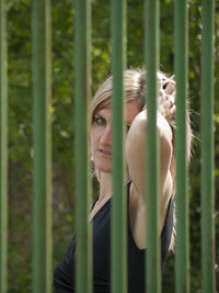 Close-up portrait of young woman standing in grass