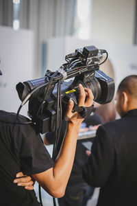 Midsection of woman holding home video camera