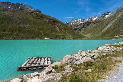 Scenic view of lake by mountains against sky