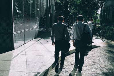 Rear view of man walking on footpath