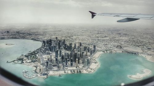 Aerial view of airplane flying over cityscape