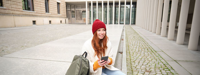 Rear view of woman standing on footpath