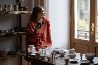 Rear view of woman looking through window