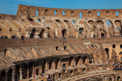 Tourists visiting the interior of the famous colosseum in rome