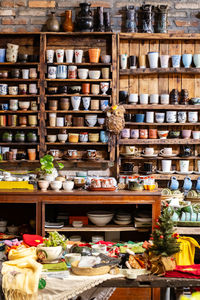 Small store with many pottery ceramic standing on shelves.