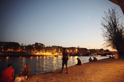 People at beach against clear sky at night