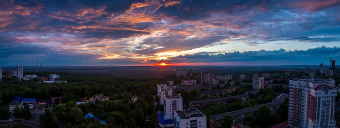 Aerial view of cityscape against cloudy sky