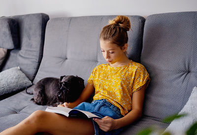 Portrait of boy sitting on sofa at home