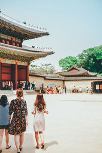 Rear view of people walking on building