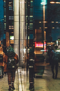 Rear view of man walking on street at night