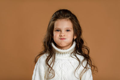 Portrait of young woman against yellow background