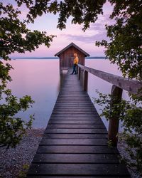 Wooden pier over lake against sky