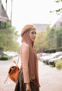 Young woman standing on road in city