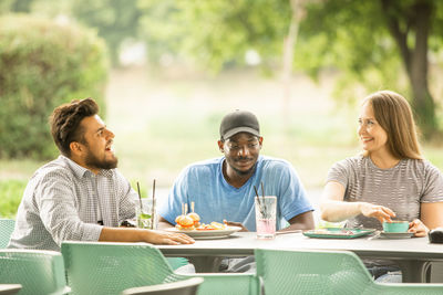 Smiling friends having food in cafe