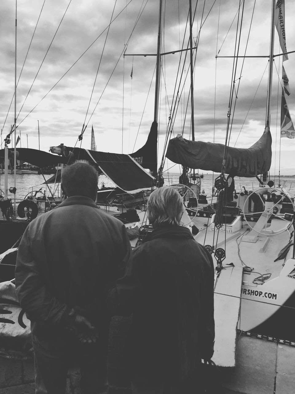 men, nautical vessel, transportation, lifestyles, mode of transport, rear view, leisure activity, boat, occupation, sky, working, harbor, person, water, travel, sitting, mast