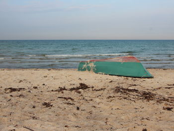 Deck chairs on beach against sky