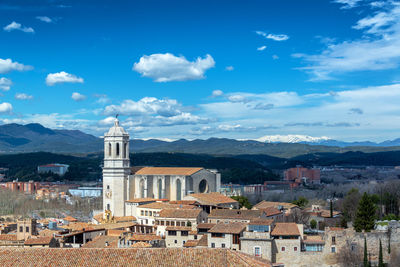 View of buildings in town against cloudy sky