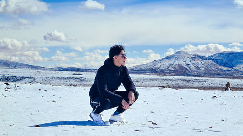 Side view of woman standing on snow covered mountain