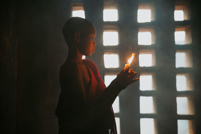 Reflection of man on mirror against wall