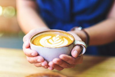 Close-up of hand holding coffee cup