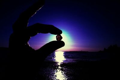 Silhouette of woman in sea at sunset