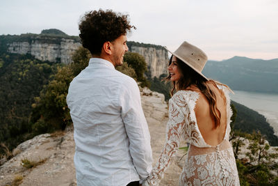 Friends standing on mountain against sky