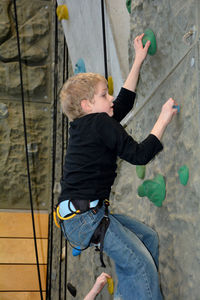 A boy climbs in a climbing hall
