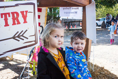 Portrait of siblings sitting at entrance