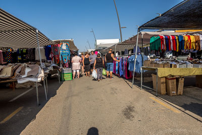 People at street market in city against sky