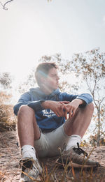 Man looking at camera while sitting on mobile phone