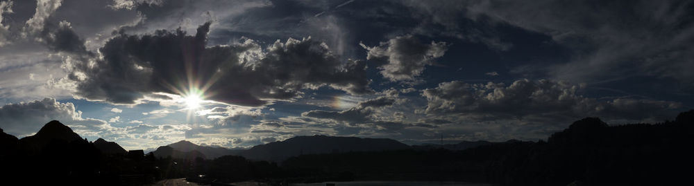 Panoramic view of silhouette mountains against storm clouds