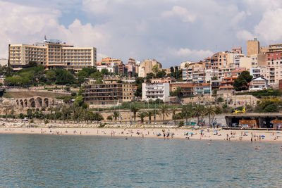 View of townscape by sea against sky