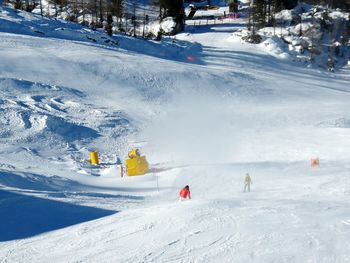 High angle view of people skiing on snow covered hill