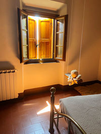 View of illuminated lamp on table by window at home