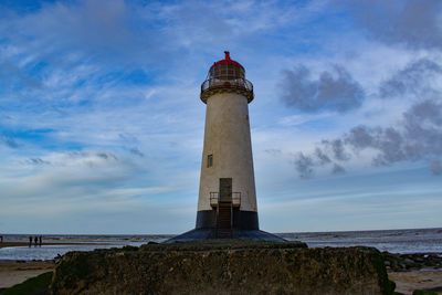 Low angle view of lighthouse by sea against sky