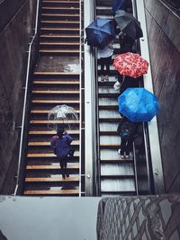 High angle view of people on steps and escalator during rainy season