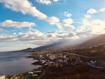 High angle view of townscape by sea against sky