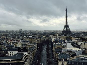 Aerial view of buildings in city against cloudy sky