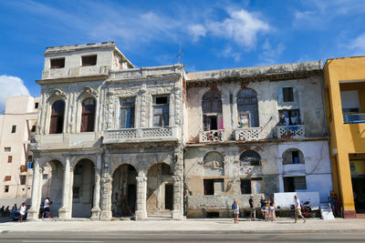 People in historic building against sky in city