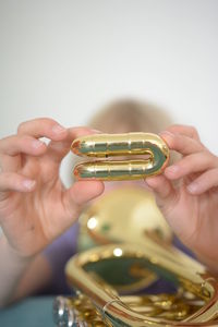 Close-up of person holding gold colored equipment