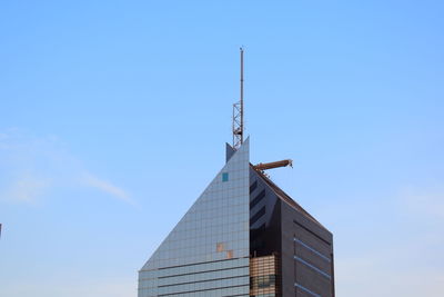 Low angle view of weather building against blue sky