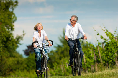 Rear view of man riding bicycle on plants
