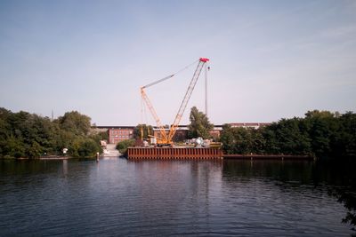 Built structure by river against sky