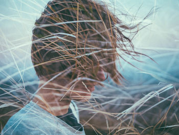 Double exposure of grass and woman with tousled hair