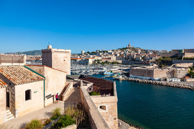 Buildings in town against clear blue sky