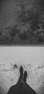 Low section of person on snow against sky during winter