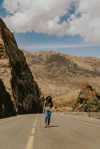 Rear view of woman on road against sky