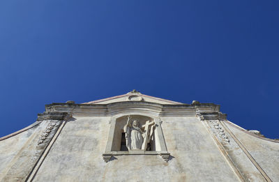 Low angle view of statue against clear blue sky