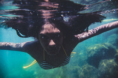 Close-up portrait of young woman swimming in sea